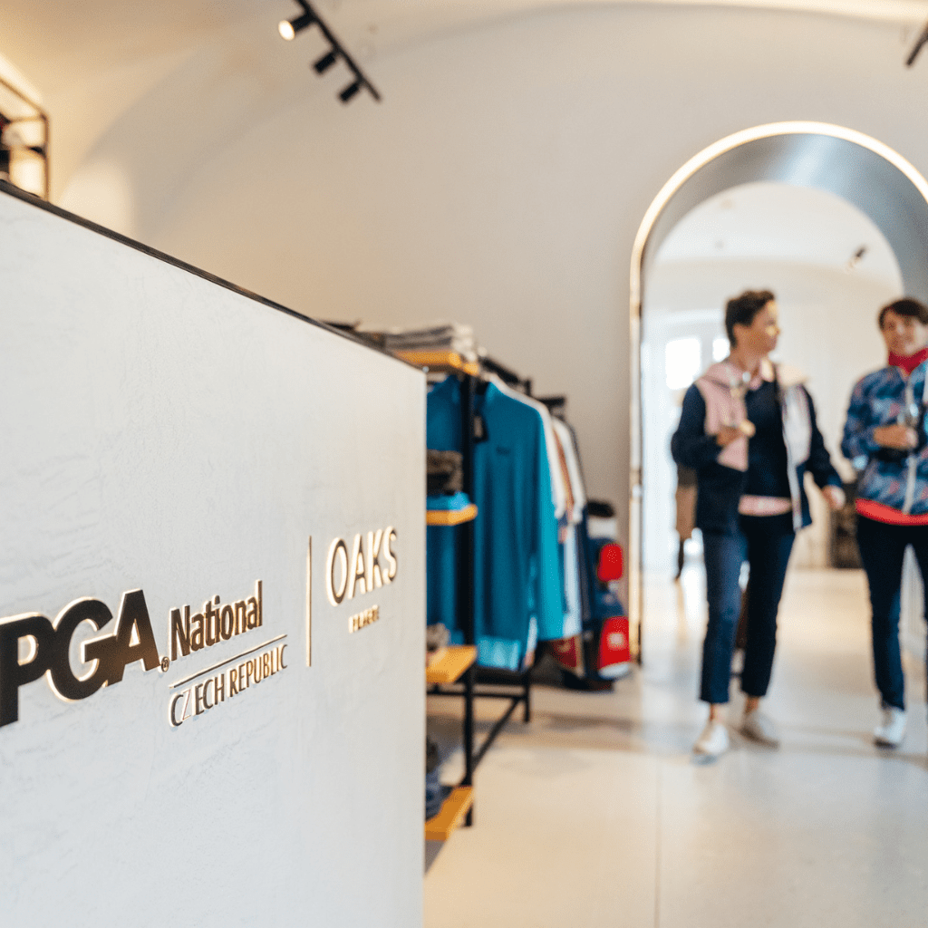 Two female golfers walking through the new golf shop inside Nebrenice Chateau at PGA National Czech Republic