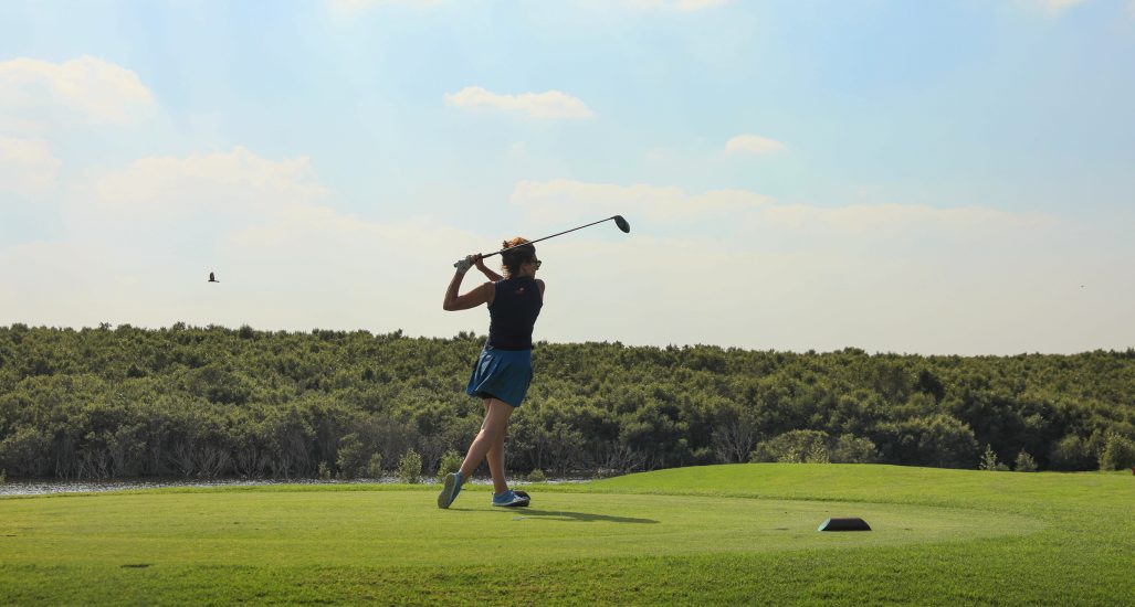 A female golfer on the course at Al Zorah Golf Club