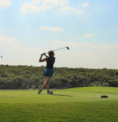 A female golfer on the course at Al Zorah Golf Club